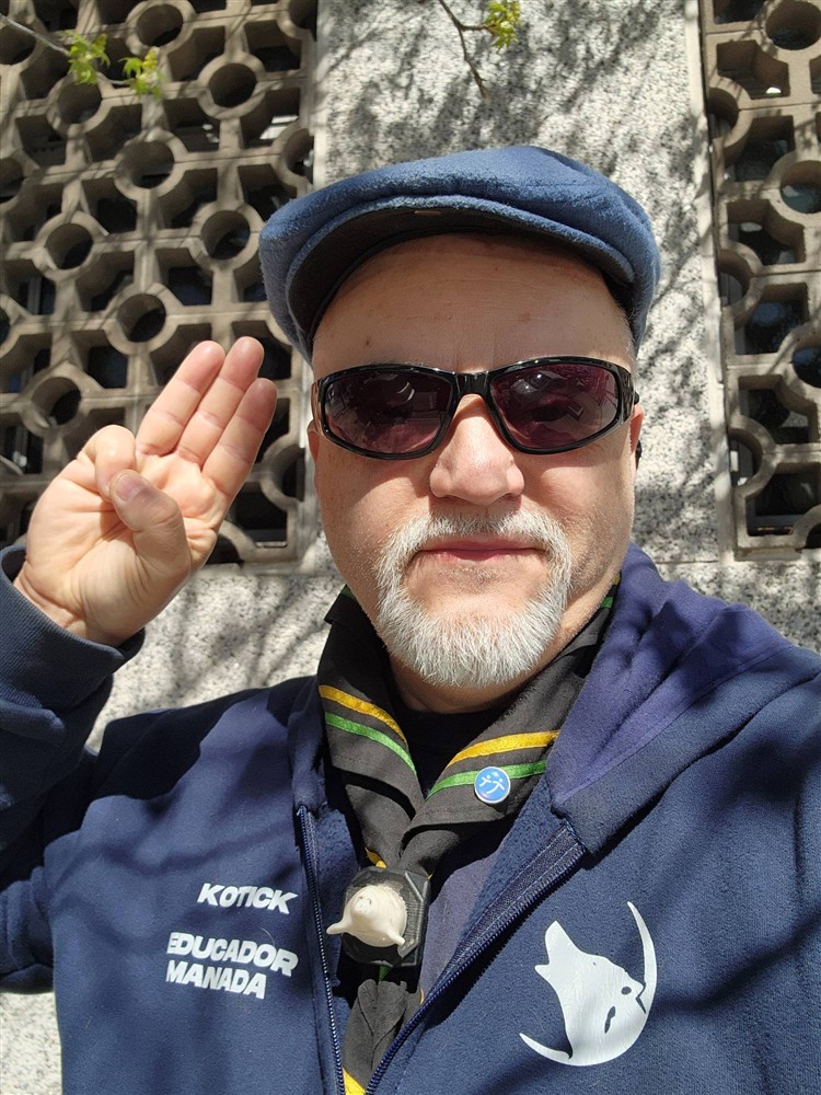 Saludo scout con el uniforme de Educador de Manada
